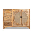 White background image of a hand carved mango wood cabinet in natural finish with 3 drawers and 2 rattan doors.
