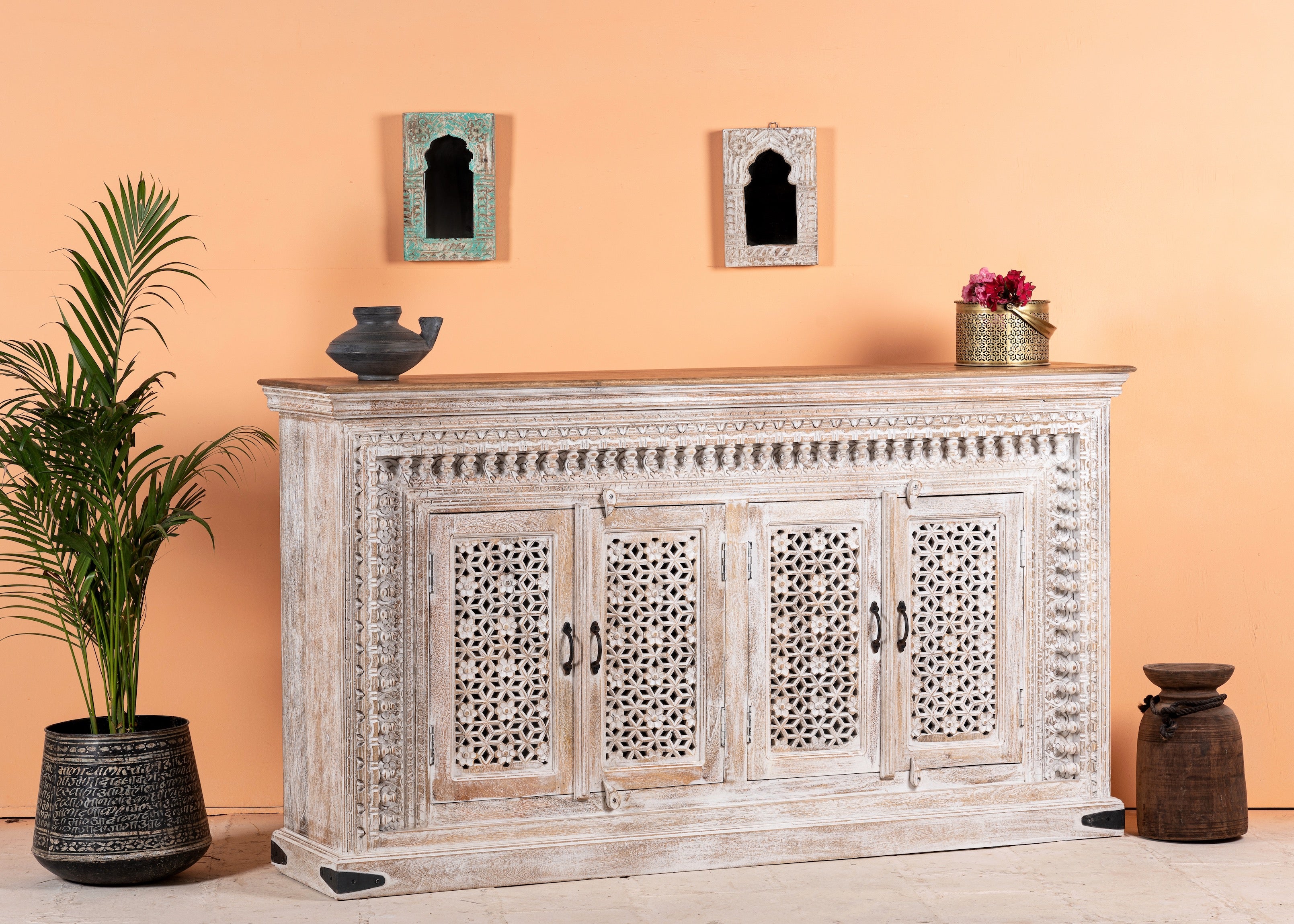 Side angle image of a Rajula handcrafted solid mango wood sideboard with hand-carved floral doors, whitewashed finish, four spacious storage compartments, and traditional Indian craftsmanship, 180cm.