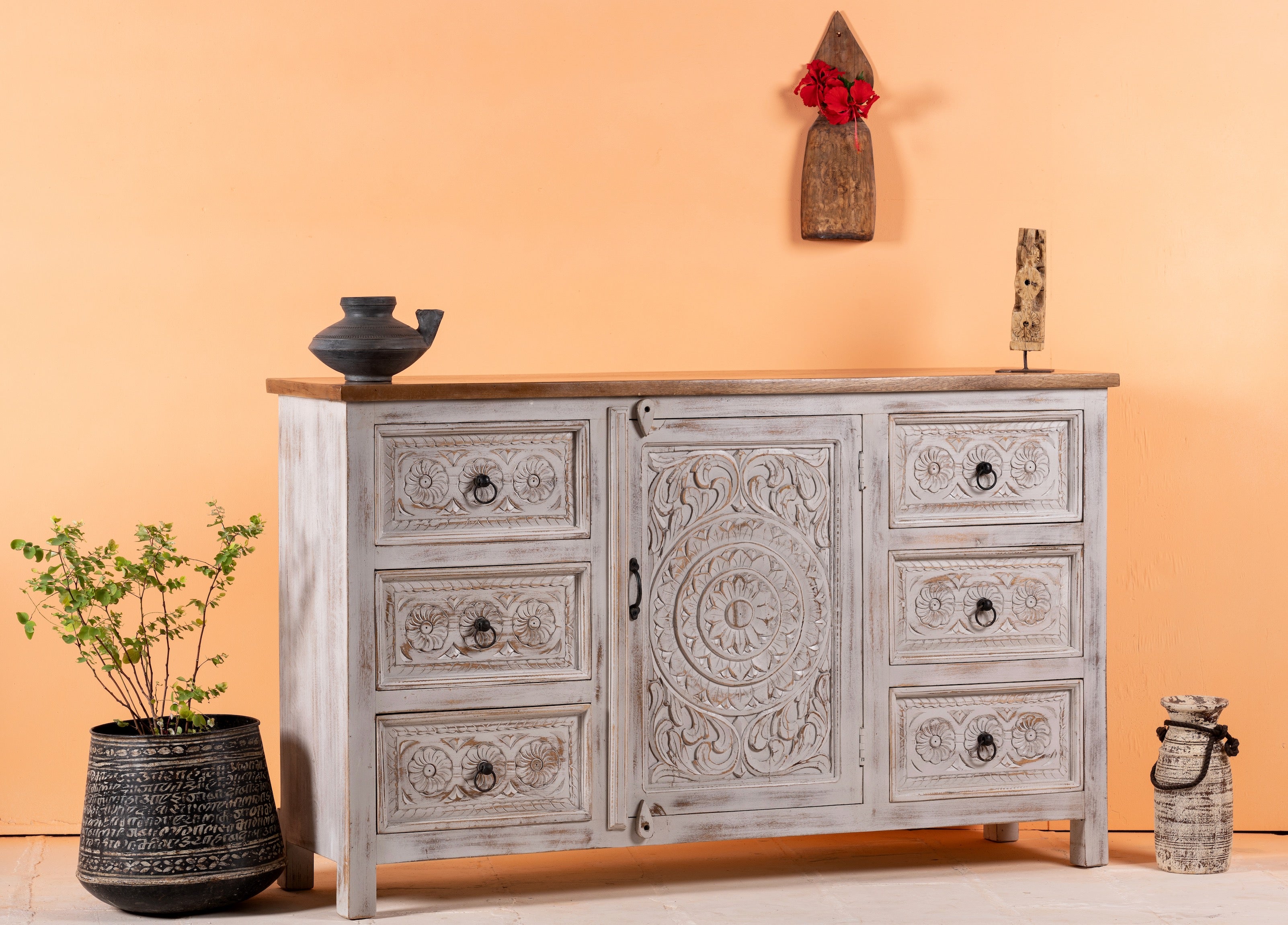 Side angle image of a handcrafted mango wood sideboard with carved floral motifs, whitewashed base and natural top; perfect for vintage home decor and living room furniture, 150 × 40 × 90 cm.