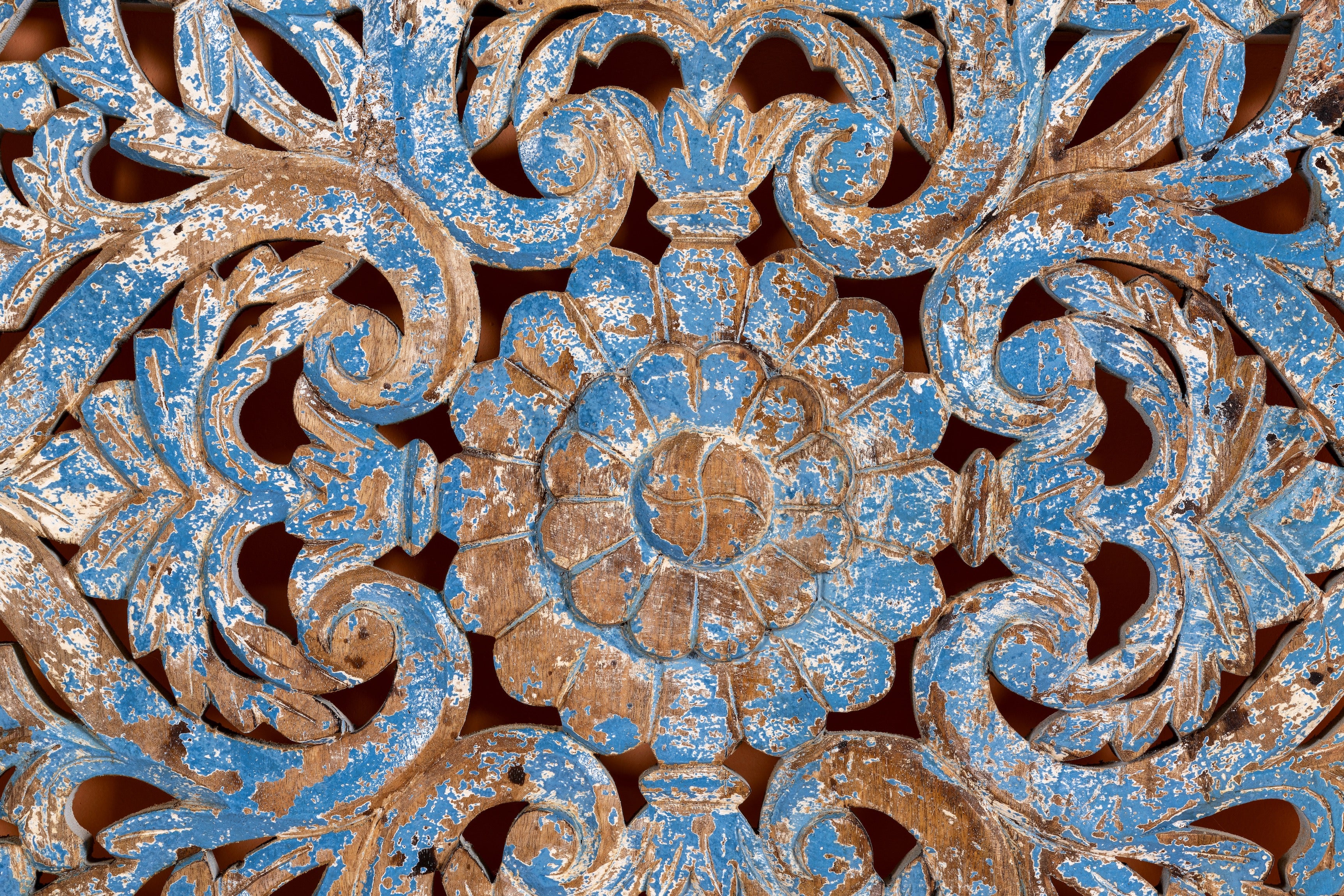 Close up image of a Shay carved wooden wall panel made from mango wood with soft floral hand-carving—an artisan wooden wall decoration with natural beauty and handcrafted detail.