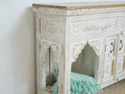 Side angle image of a Teerth hand carved white washed mango wood console table with natural wood top 150cm