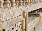 Close up image of a carved mango wood TV unit with hand-carved doors, one drawer, and open shelf, 150 × 60 × 40 cm.